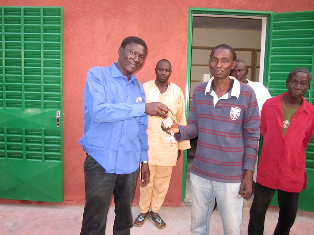 Building architect handing keys to the Yelbouga CVD president.