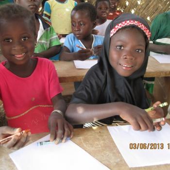 Children thrilled to receive crayons and a sheet of paper.